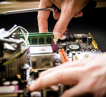Hände bei der Reparatur einer elektronischen Platine